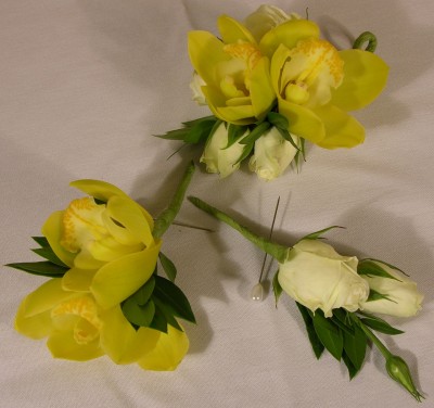 Yellow cymbidium orchid and white spray rose boutonnieres
