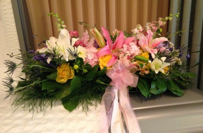 Casket spray with lilies, roses, sea holly ($250)